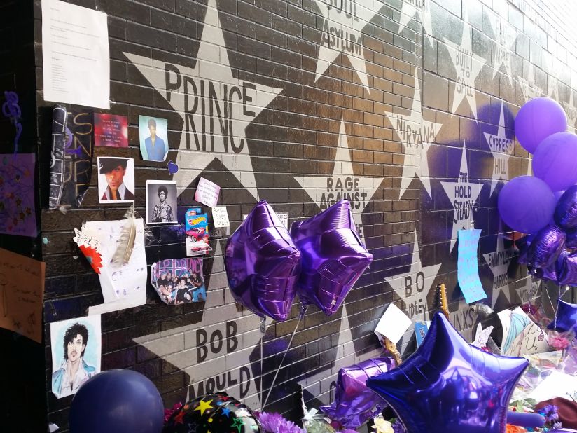 <strong>First Avenue star wall -- </strong>Outside, silver stars bear the names of past performers. A shrine has been started by Prince's name.  