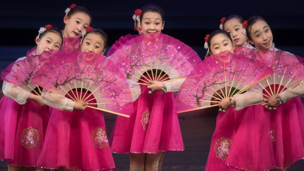 Children with fans entertain foreign journalists.