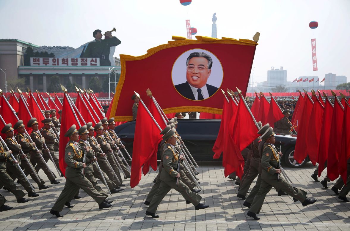 North Korean soldiers carry flags and a photo of late leader Kim Il Sung as they march across Kim Il Sung Square.