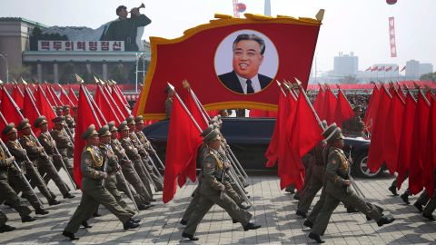 North Korean soldiers carry flags and a photo of late leader Kim Il Sung as they march across Kim Il Sung Square during a military parade on Saturday.