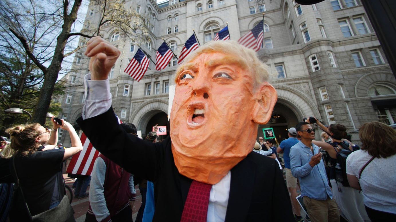 Protesters gather during a Tax Day demonstration in front of the Trump International Hotel in Washington. 