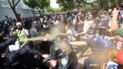 A man gets sprayed with a chemical irritant as multiple fights break out between Trump supporters and anti-Trump protesters in Berkeley, California on April 15, 2017.