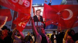 Supporters of Justice and Development party wave Turkish flags and hold a poster of Turkish President Recep Tayyip Erdogan outside its offices in Istanbul, Sunday, April 16, 2017. 