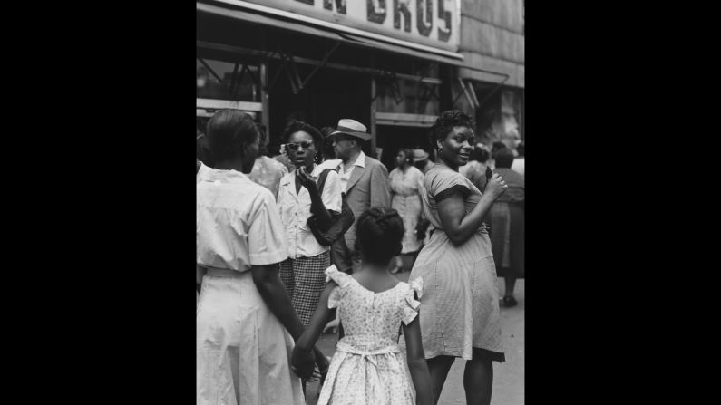 A woman looks at the camera on 125th Street in Harlem. "Webb's stunning photographs capture New York's iconic sites as well as fleeting, magical moments in the life of the city," according to The Curator Gallery.