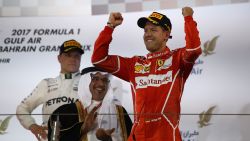 BAHRAIN, BAHRAIN - APRIL 16:  Race winner Sebastian Vettel of Germany and Ferrari celebrates his win on the podium during the Bahrain Formula One Grand Prix at Bahrain International Circuit on April 16, 2017 in Bahrain, Bahrain.  (Photo by Clive Mason/Getty Images)