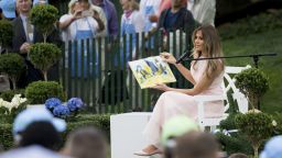 First Lady Melania Trump reads a book during the 139th White House Easter Egg Roll on the South Lawn of the White House in Washington, DC, April 17, 2017. 