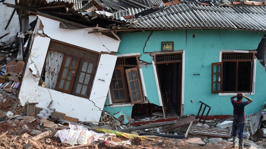 TOPSHOT - A Sri Lankan resident walks through damaged homes at the site of a collapsed garbage dump in Colombo on April 16, 2017. 
Hopes of finding anyone alive under a collapsed mountain of garbage in Sri Lanka's capital faded as the death toll reached 23 with another six reported missing, police said. Hundreds of soldiers, backed by heavy earth moving equipment were digging through the rubbish and the wreckage of some 145 homes that were destroyed when a side of the 300-foot (90-metre) high dump crashed on April 14.
 / AFP PHOTO / ISHARA S. KODIKARA        (Photo credit should read ISHARA S. KODIKARA/AFP/Getty Images)