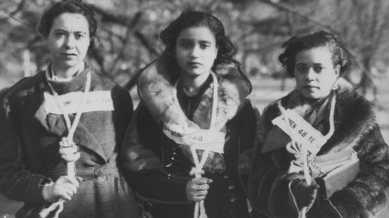 Three women stand with nooses around their necks during a 1946 protest of lynchings.