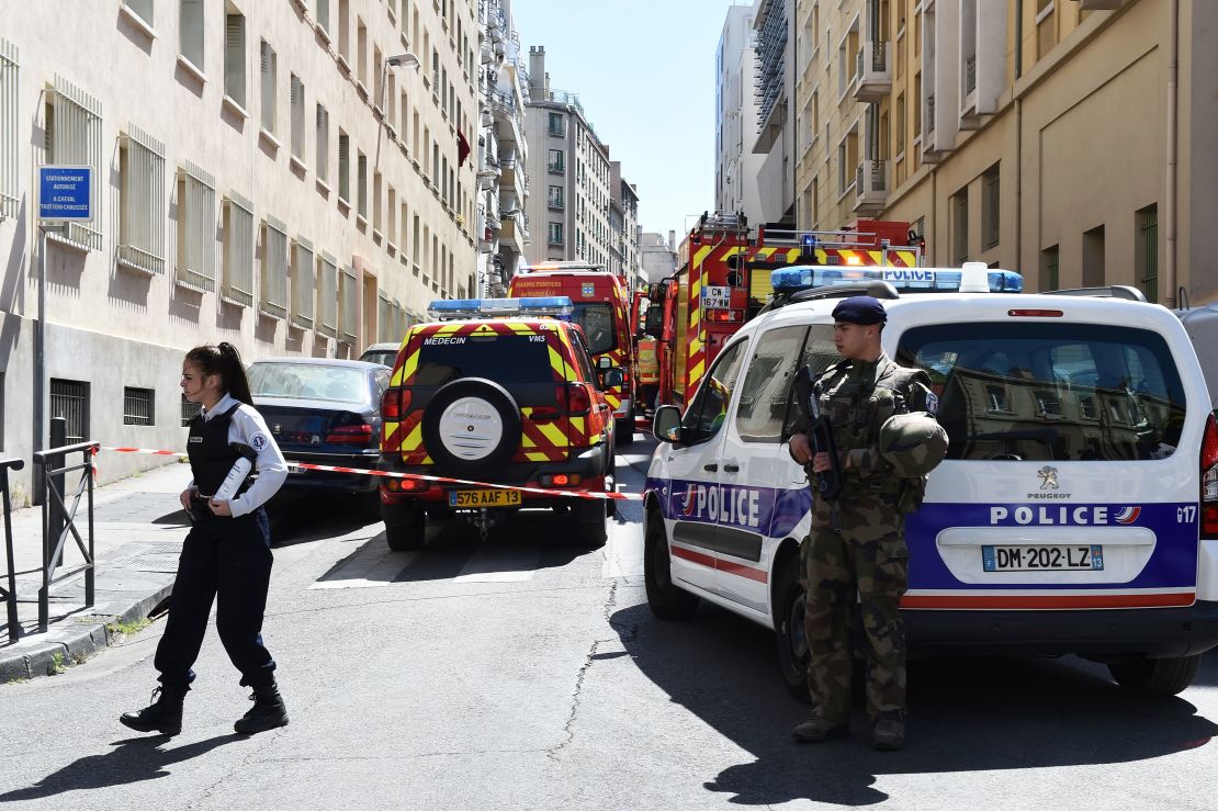 French security service at the site of a police search at the home of one of two men arrested on suspicion of preparing an attack just days ahead of the first round of France's presidential vote.