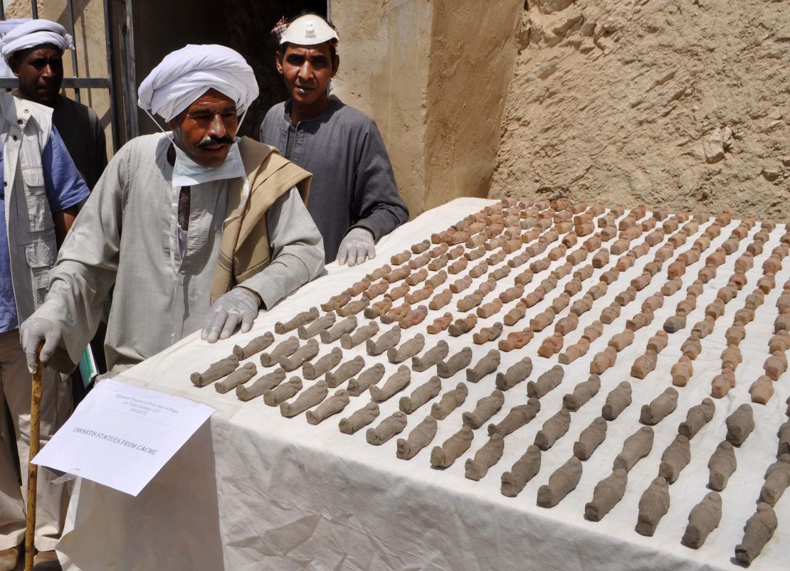 Members of the Egyptian archaeological mission eye funerary figurines known as ushabtis.