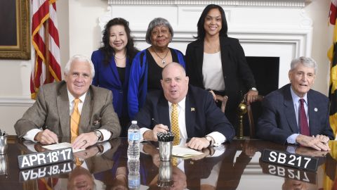 Maryland Governor Larry Hogan signs SB 217 surrounded by state and local law enforcement officials.