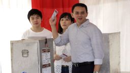 Jakarta Governor Basuki "Ahok" Tjahaja Purnama who is seeking for his second term in office, his wife Veronica and son Nicholas, left, cast their ballot at a polling station during the runoff election in Jakarta, Indonesia, Wednesday, April 19, 2017. Residents of the Indonesian capital are electing a governor after a polarizing campaign that undermined Indonesia's reputation for practicing a tolerant form of Islam. (AP Photo/Tatan Syuflana)