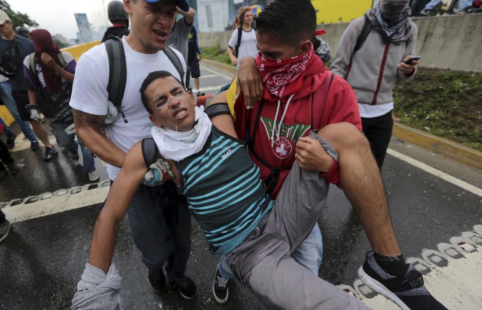 A protester suffering from the effects of tear gas is carried away on Thursday, April 13.