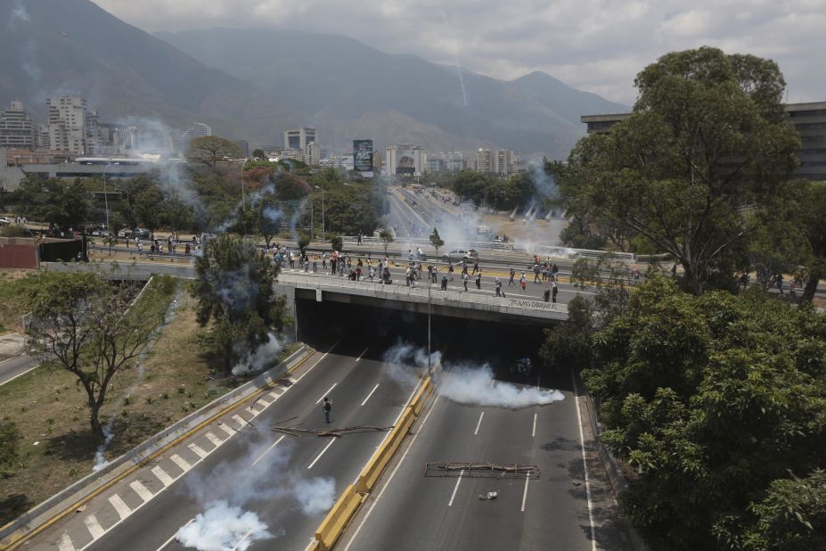 Clouds of tear gas spread across a highway in Caracas during clashes on Monday, April 10.