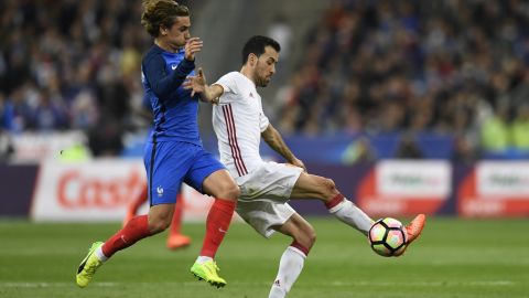 Sergio Busquets evades the challenge of France's Antoine Griezmann with a deft touch.