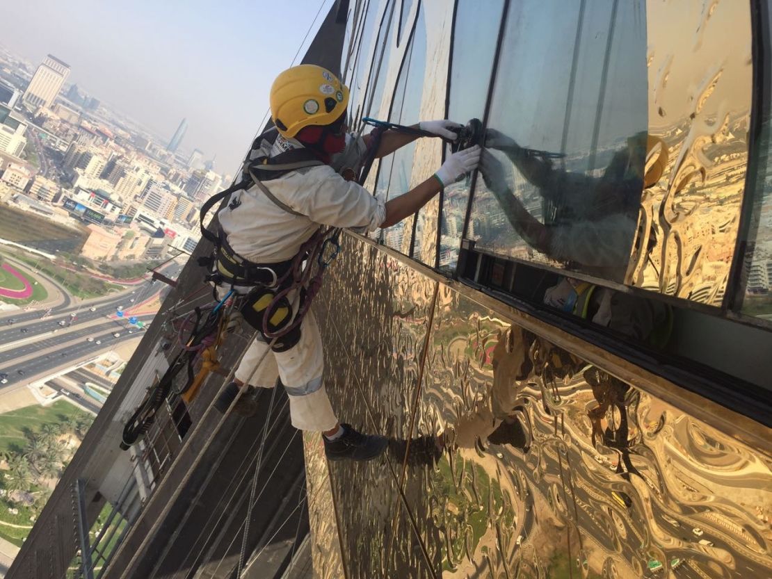Workers from Megarme Rope Access installing the stainless steel gold cladding.