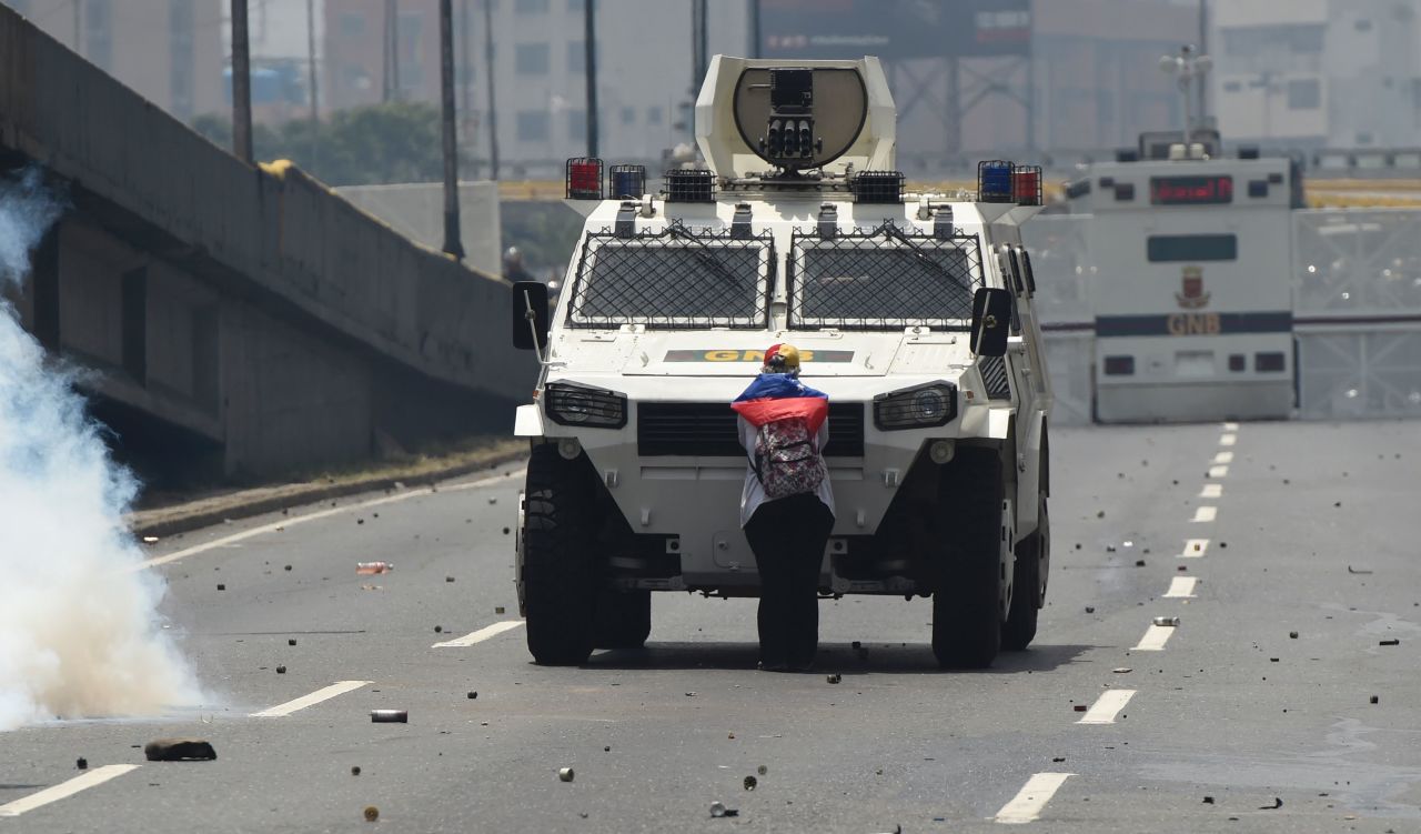 A demonstrator stands in front of an armored vehicle during protests in Caracas on Wednesday, April 19.