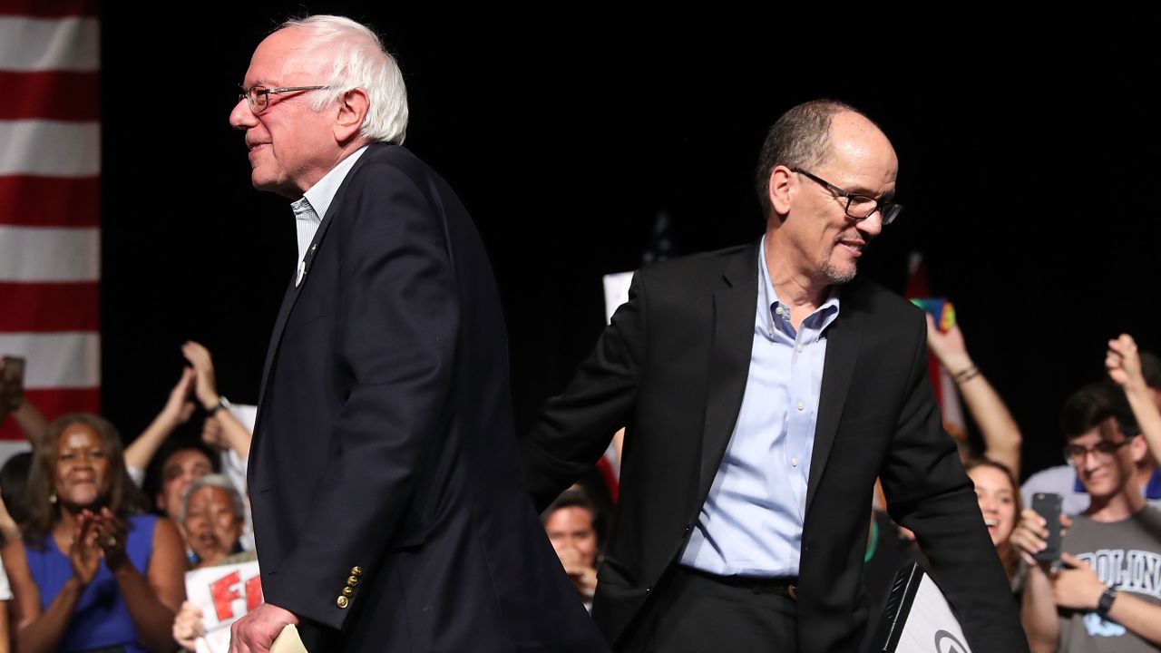 Sen. Bernie Sanders and DNC Chair Tom Perez walk past each other as Sanders takes to the stage to speak during their "Come Together and Fight Back" tour at the James L Knight Center on April 19, 2017 in Miami, Florida.