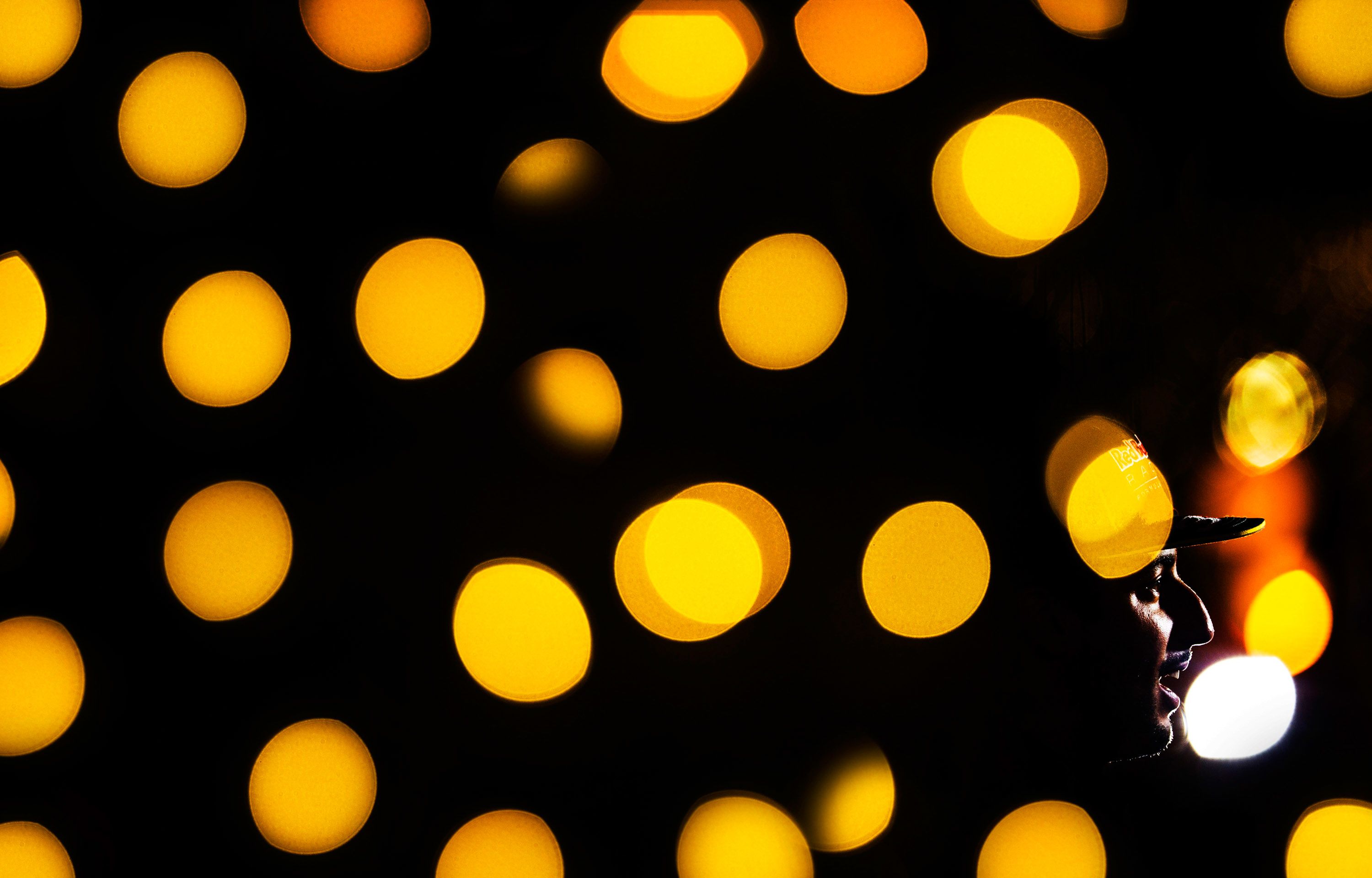 Red Bull Racing driver Daniel Ricciardo amid glimmering lights in the F1 paddock.<br />© Darren Heath <br />