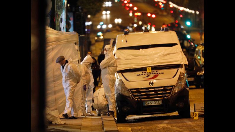 A forensic team investigates the scene where an attacker opened fire on police with an automatic weapon.