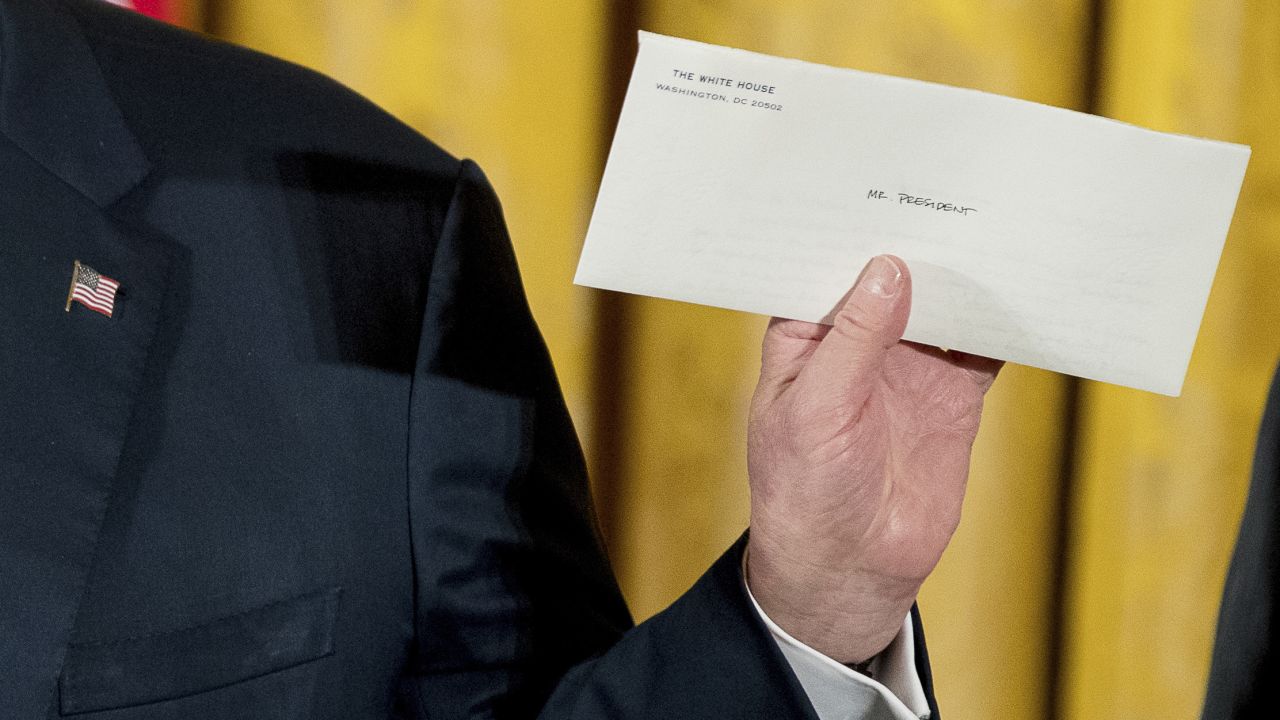 Trump holds up a letter Sunday, January 22, that was left for him by former President Barack Obama. "I just went to the Oval Office and found this beautiful letter from President Obama. It was really very nice of him to do that. And I will cherish that," said Trump, <a href="http://www.cnn.com/2017/03/04/politics/donald-trump-obama-quotes/" target="_blank">who frequently criticized Obama</a> on the campaign trail. Trump wouldn't tell the press what was in the letter.