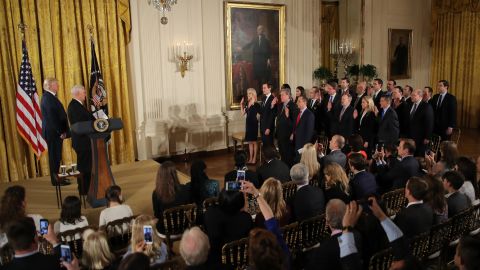 Trump, left, watches Vice President Mike Pence swear in senior White House staff members on January 22. Trump said he and his aides will "face many challenges, but with the faith in each other and the faith in God we will get the job done."