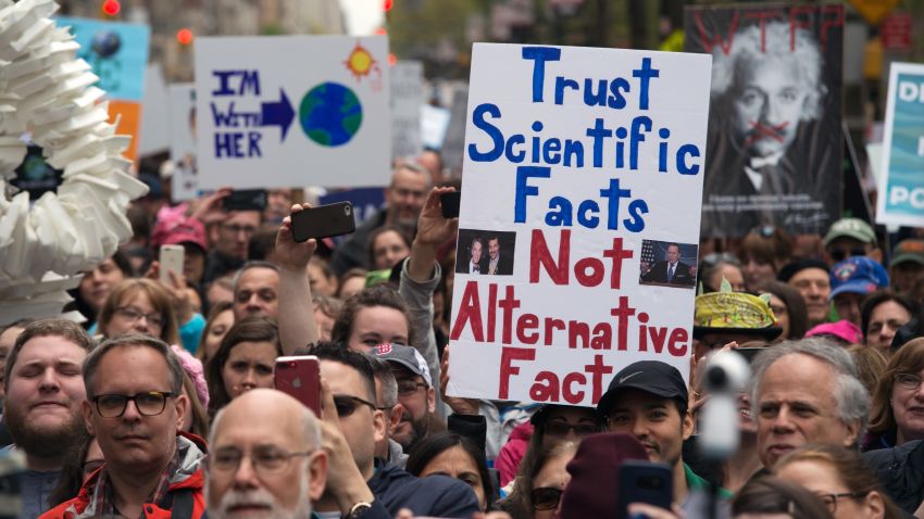 People hold up signs at a rally before the march for Science April 22, 2017 in New York. Scientists and their supporters across the globe are expected to march in the thousands Saturday amid growing anxiety over what many see as a mounting political assault on facts and evidence.
