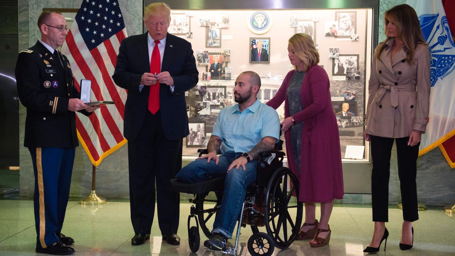 US President Donald Trump awards the purple heart to Sergeant First Class Alvaro Barrientos as first lady Melania Trump and Barrientos' wife Tammy stand by. 