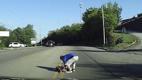 A medical technician rescues a 4-year-old girl who fell from a moving bus Wednesday in Arkansas.