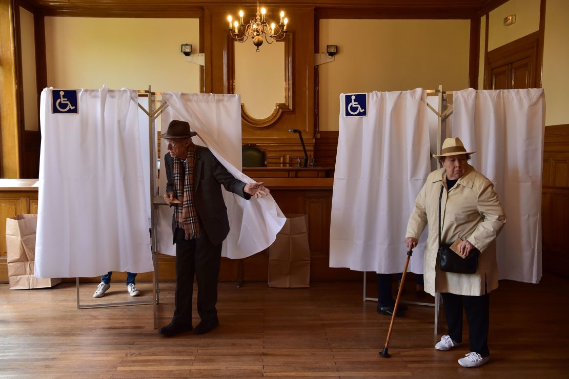 Voters leave their booths in the 7th district in Paris on Sunday to cast their ballots.