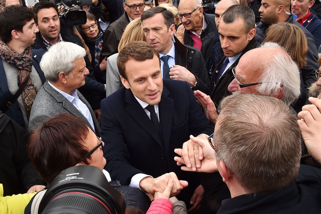 French presidential candidate for the En Marche! movement Emmanuel Macron shakes hands with supporters after casting his vote in Le Touquet.