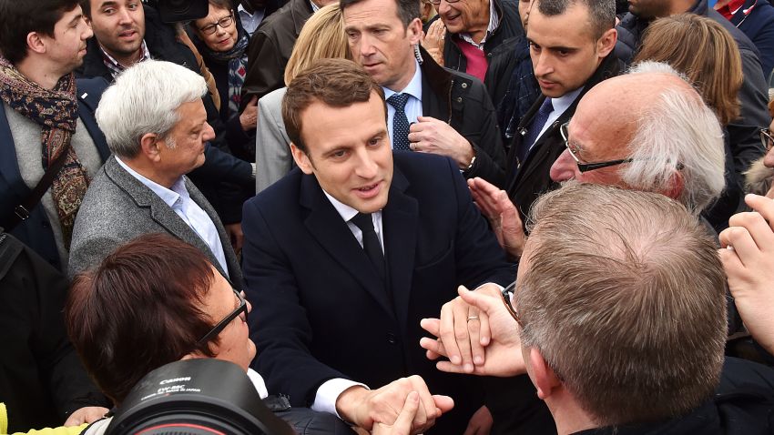 French presidential election candidate for the En Marche ! movement Emmanuel Macron shakes hands with supporters after voting at a polling station in Le Touquet, northern France, on April 23, 2017, during the first round of the Presidential election. / AFP PHOTO / Philippe HUGUEN        (Photo credit should read PHILIPPE HUGUEN/AFP/Getty Images)
