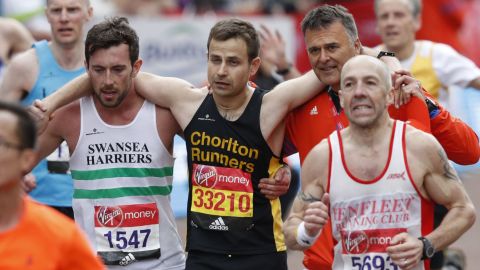 Matthew Rees helps David Wyeth reach the finish line during the London marathon. 