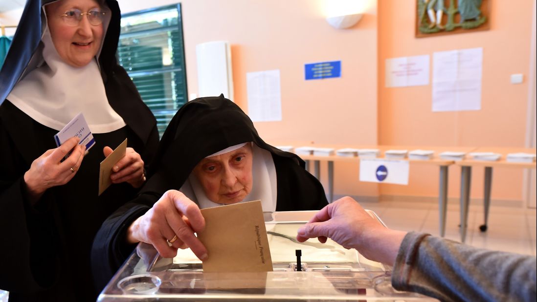 A Benedictine sister of the Sainte-Cecile Abbey casts her ballot at a polling station in Solesmes.
