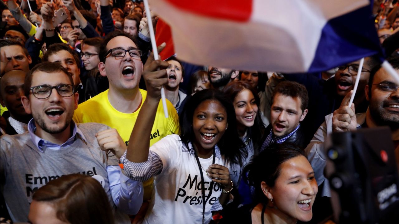 Supporters of Macron cheer in Paris after the announcement that he qualified for the runoff.