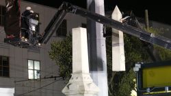 Workers dismantle the Liberty Place monument Monday, April 24, 2017, which commemorates whites who tried to topple a biracial post-Civil War government, in New Orleans. It was removed overnight in an attempt to avoid disruption from supporters who want the monuments to stay. (AP Photo/Gerald Herbert)