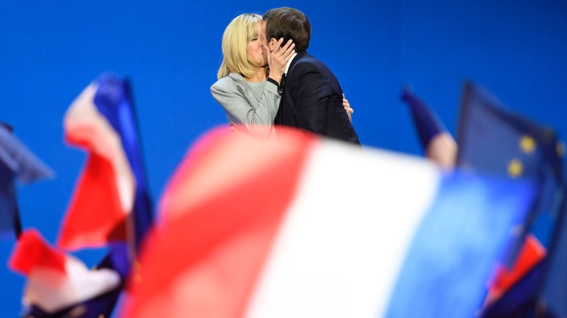 Macron kisses his wife after winning the first round in April.