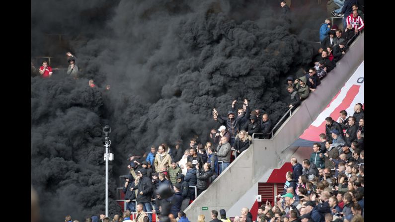 Black smoke engulfs part of the crowd after smoke bombs interrupted a soccer match in Eindhoven, Netherlands, on Sunday, April 23. A few fans had to receive medical treatment.