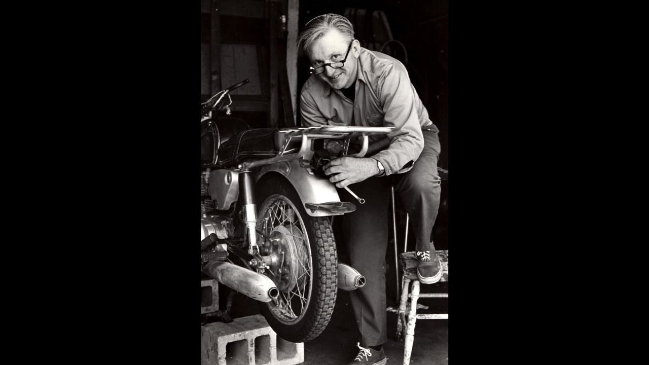 Robert M. Pirsig works on a motorcycle in 1975.