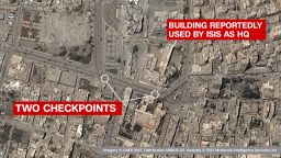 Checkpoints in front of reported ISIS HQ: The images clearly show two checkpoints in the main road outside a key governate building, which ISIS have reportedly used as a headquarters. The building itself is -- on the satellite imagery -- seen as damaged but still standing, suggesting a precision coalition airstrike.