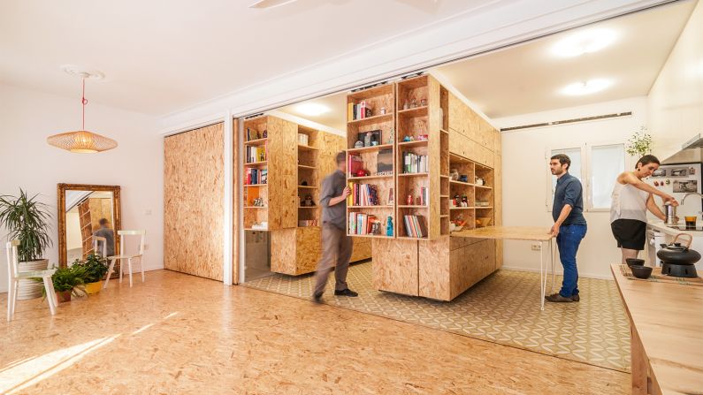 The movable shelving units in this apartment slide to convert this space from kitchen to bedroom. 
