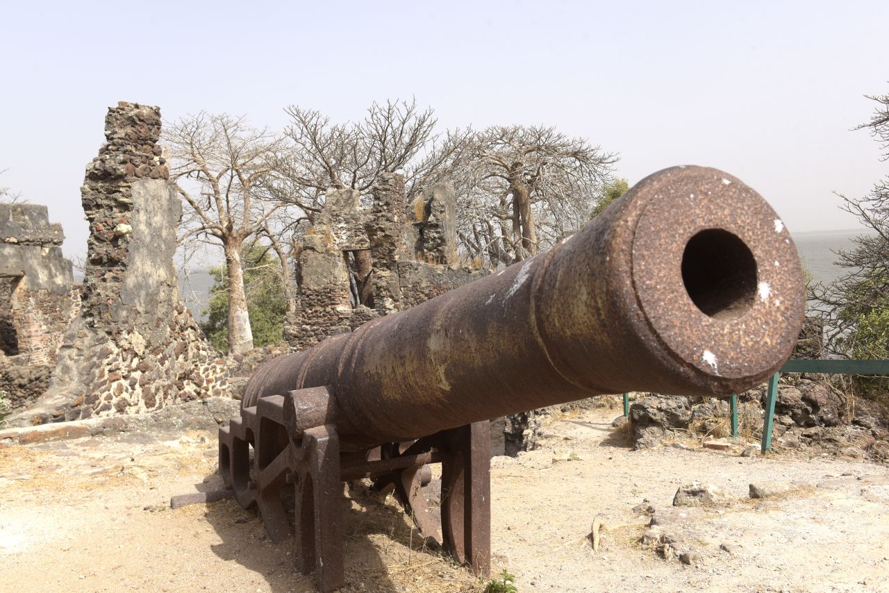 A rusted cannon on the beach of Kunta Kinteh Island, formerly James Island, in the Gambia River. <br /><br />The island was a longtime hub of the Atlantic slave trade, and famous rebel slave Kunta Kinte was once held there. 