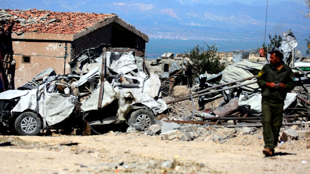 A YPG fighter surveys the site of Turkish airstrikes Tuesday in northeastern Syria near Turkey.