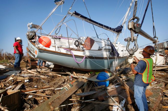 Workers prepare to remove a sailboat on September 21, 2008. Hurricane Ike pushed the vessel onto the edge of a highway in Galveston, Texas.