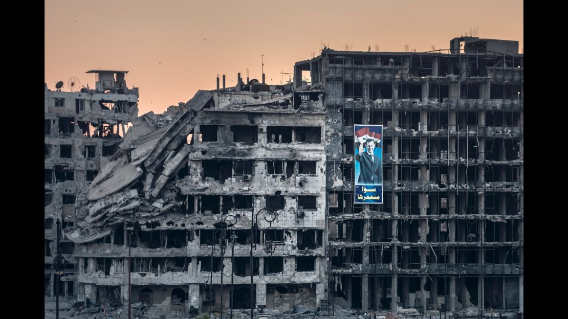 An election campaign poster for President Bashar al-Assad hangs on a ruined shopping mall in Homs.