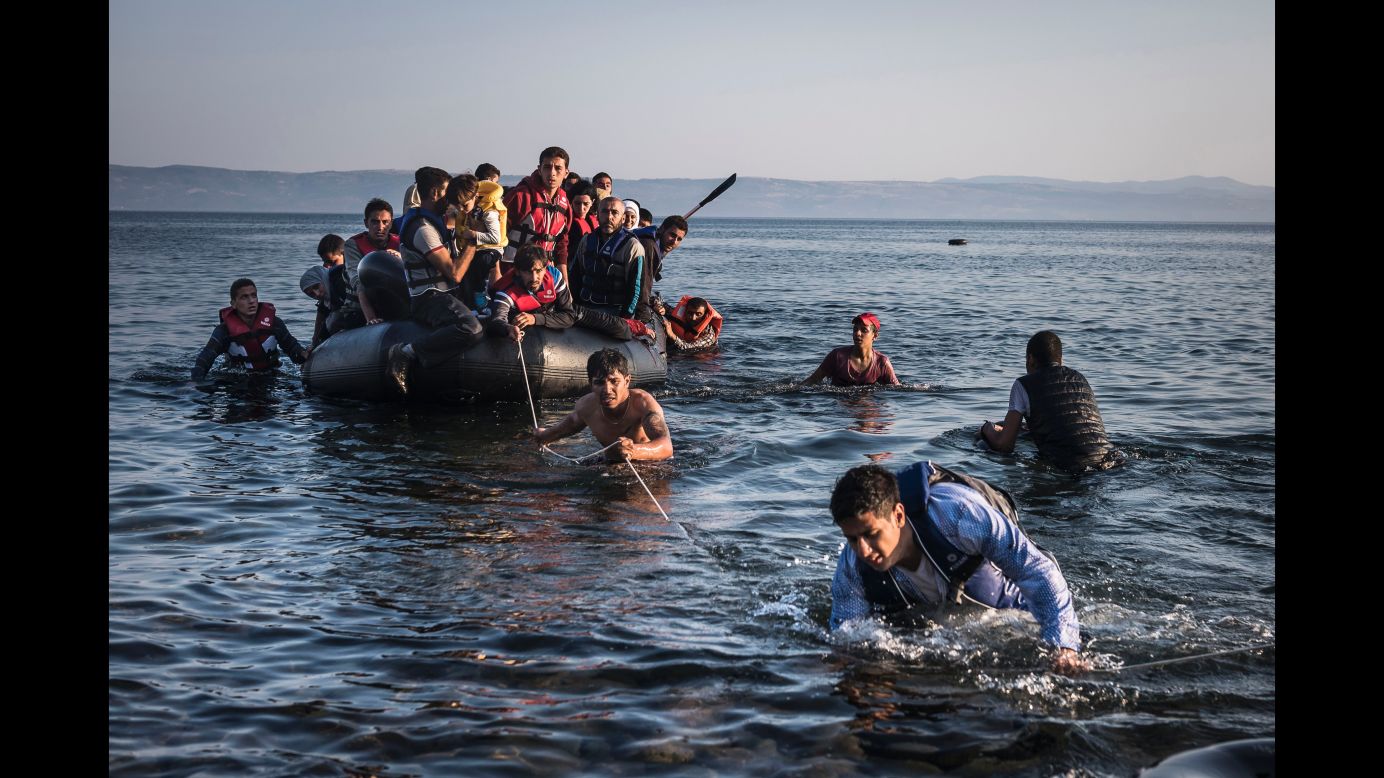 An inflatable dinghy, crowded with refugees and migrants, is pulled ashore on the Greek island of Lesbos after sailing five miles across the Aegean Sea from Turkey. (July 27, 2015)