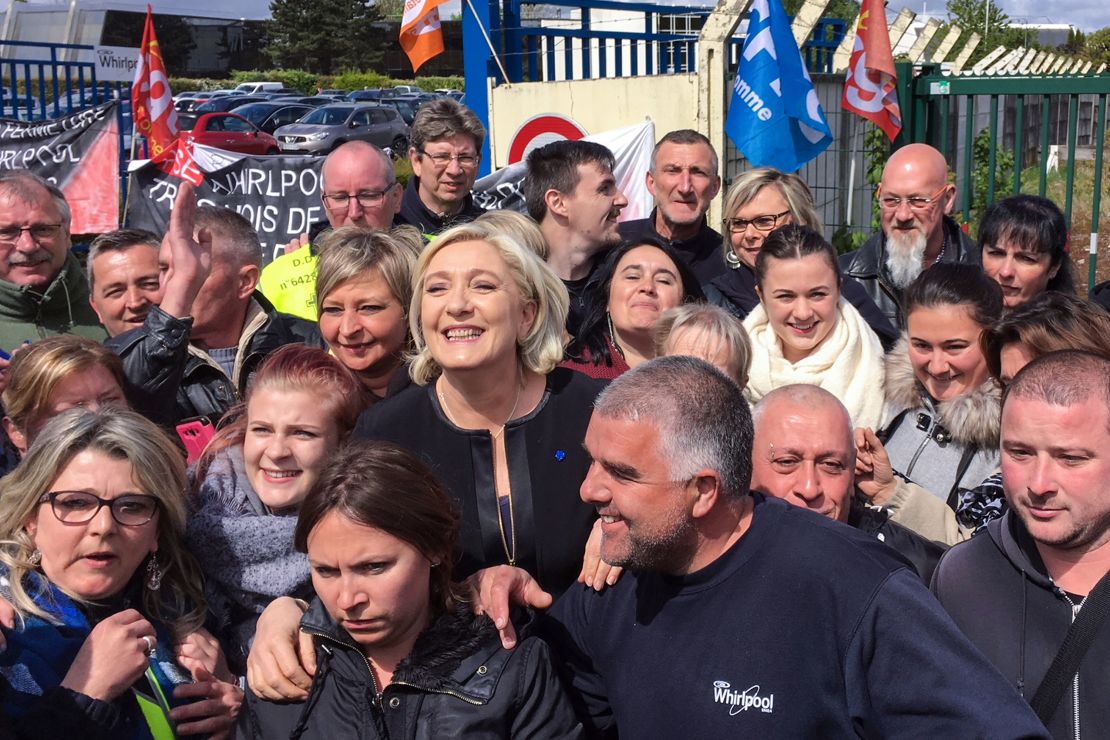 Le Pen  smiles with people in front of the Whirlpool factory in Amiens, northern France.