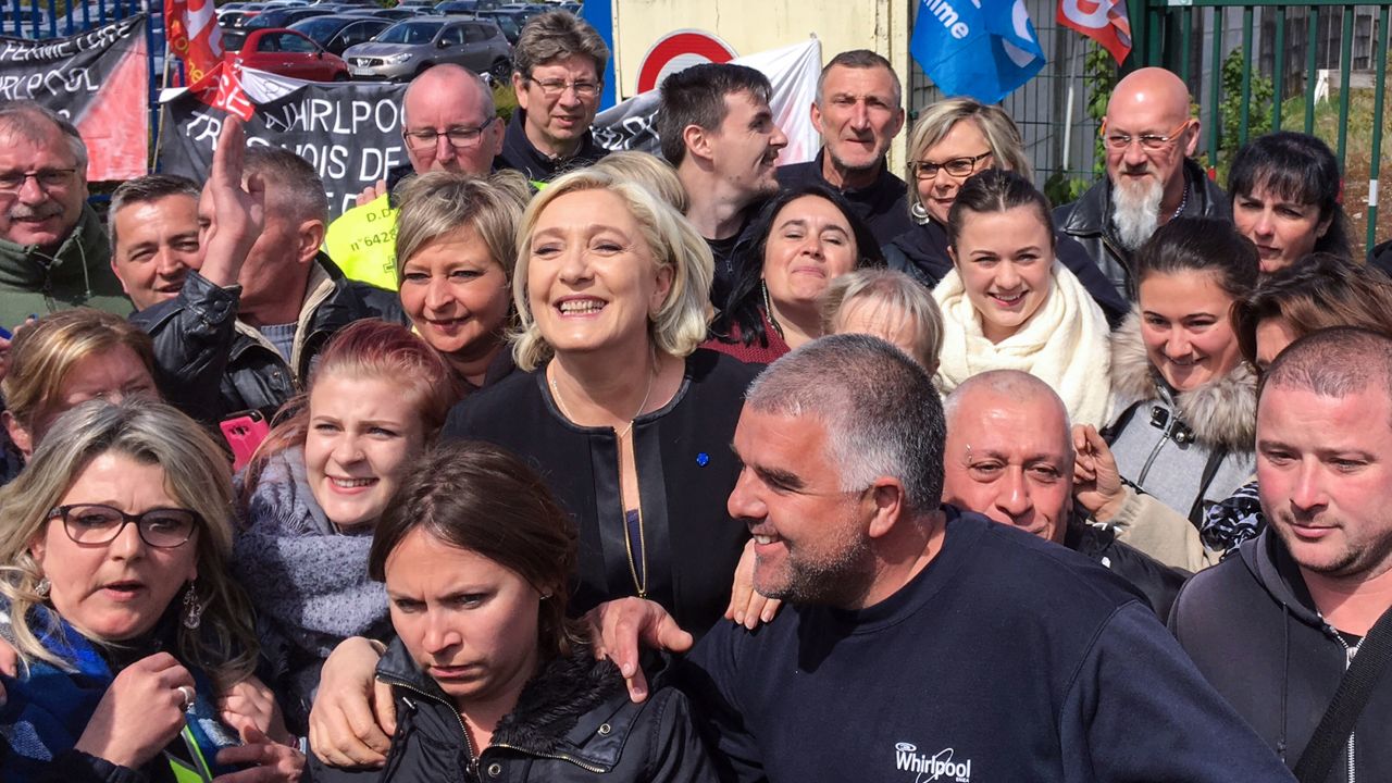 TOPSHOT - French presidential election candidate for the far-right Front National (FN) party, Marine Le Pen (C) smiles with people in front of the Whirlpool factory in Amiens, northern France, on April 26, 2017.
French far-right presidential candidate Marine Le Pen upstaged her rival Emmanuel Macron by making a surprise visit to an under-threat factory just as he was visiting the town where it is based.
 / AFP PHOTO / STR        (Photo credit should read STR/AFP/Getty Images)