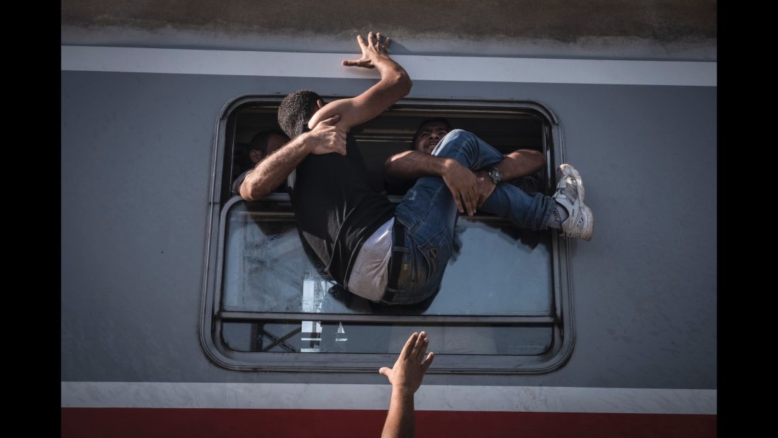 A desperate man is hauled through the window of one of the last trains to carry refugees and migrants from the Croatian border to Zagreb. (September 18, 2015)
