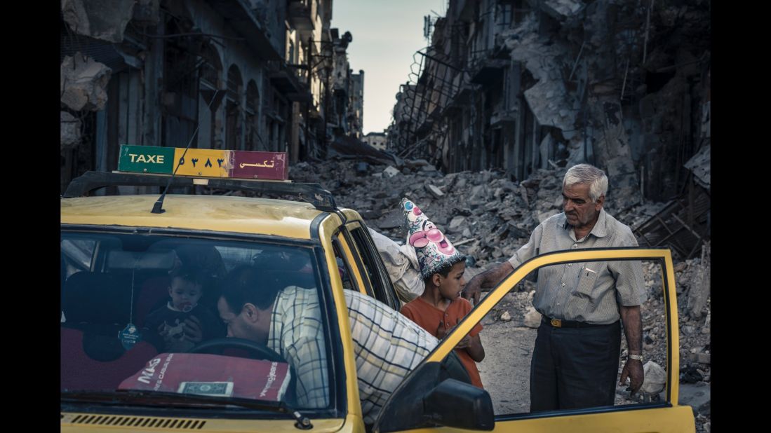 Abu Hisham Abdel Karim and his family use a local taxi to salvage possessions from their ruined apartment in the Khalidiya district of Homs shortly after the city was retaken by government forces. (June 15, 2014)